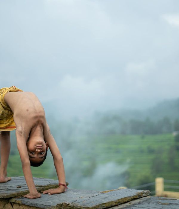 Woman meditating peacefully in a lotus pose against a dark background.